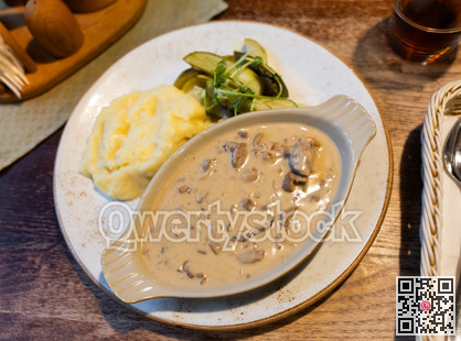 Slices of beef in mushroom sauce in a ceramic plate