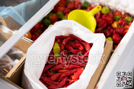Whole frozen red sweet pepper are in shopwindow refrigerator.