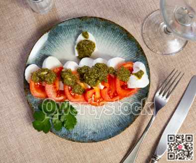 Caprese salad with pesto sauce and cilantro