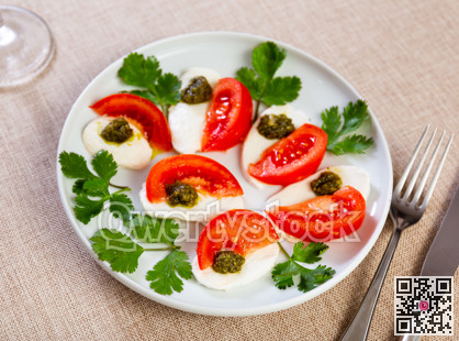 Caprese salad with pesto sauce and cilantro