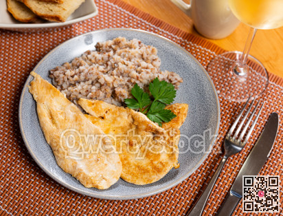 Delicious roasted turkey breast with buckwheat porridge on table