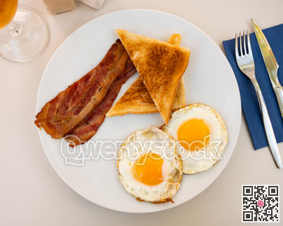 Fried chicken eggs with bacon, served with white bread toasts