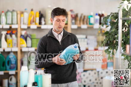Middle-aged man choosing laundry detergent at department store