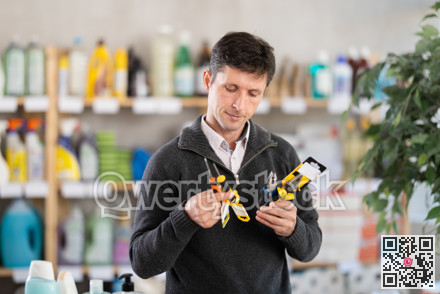 Male client in store inspects set of hand tools. Buyer selects necessary items for minor repairs