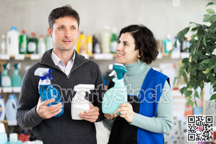 Woman seller offers cleaning spray to adult man buyer