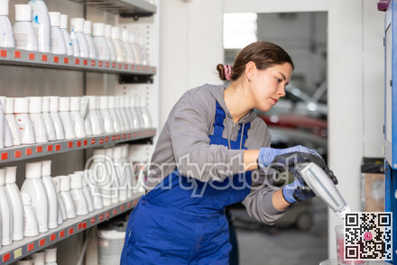 Girl colorist selects paint color by mixing different paint colors for subsequent painting of car in car service center
