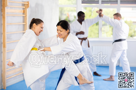Adult and young women training karate techniques