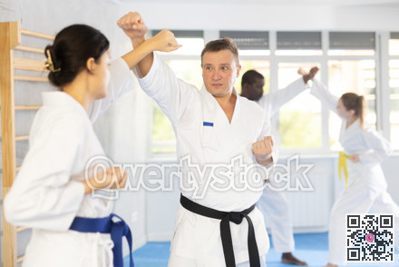 Multinational pupils train to perform defensive karate installations and attacking combat techniques
