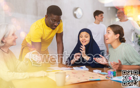 Group of multinational people playing board game