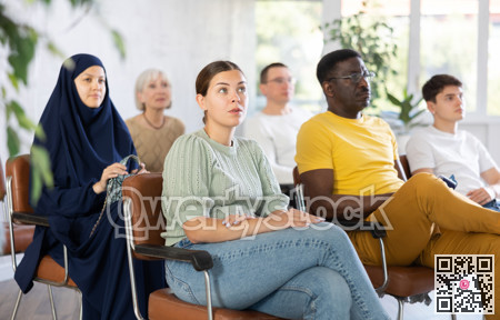 Young girl sitting at lecture with group of women and men