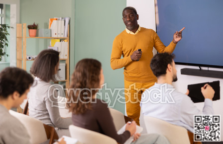 During lesson, African man teacher tells material and gives lecture