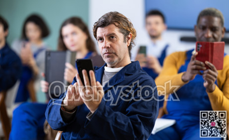 Adult man worker takes photo or scans QR code with mobile phone