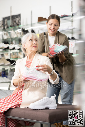 Elderly mom sits on bench and asks her daughter to advise fashionable sneakers for fitting