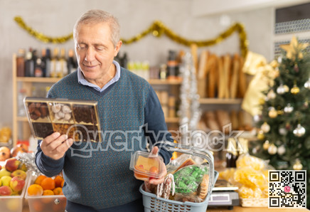 Elderly man chooses dried fruits and fruit jelly at grocery store