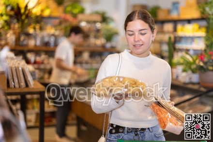 Store visitor, girl in sales area choosing pasta