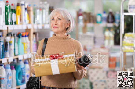 Mature woman holding present in department store