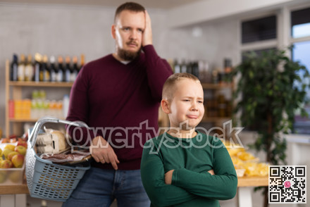 Little boy behaving capricious in grocery store