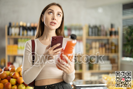 Young woman scanning qr code of grapefruit juice