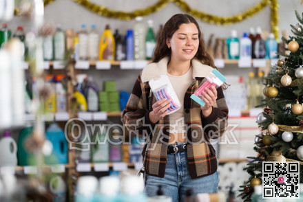 Young woman choosing razor in decorated store