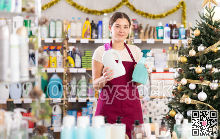 Woman seller offers spray in decorated household chemicals store