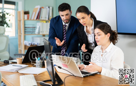 Colleagues discussing project on laptop together