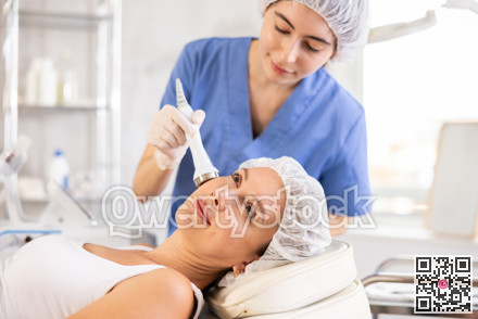 Young female cosmetologist doing ultrasound procedure to young woman