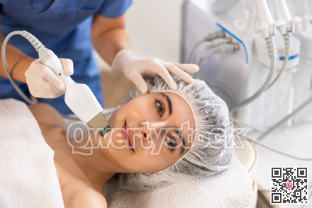 Young woman cosmetologist doing exfoliation procedure to young woman