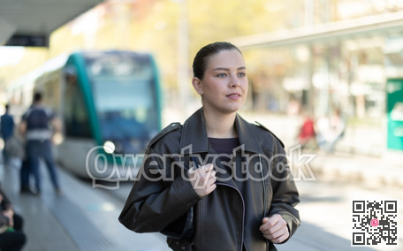 Pretty girl walks along the platform waiting for tram