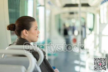 Portrait of woman in black leather jacket on tram. Traveling by public transport
