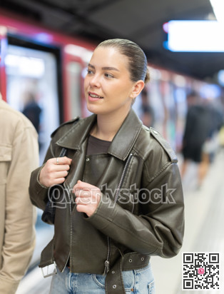 Pretty girl walks along the platform waiting for subway train