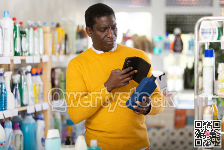 African man buyer scan QR code on packaging of spray in shop