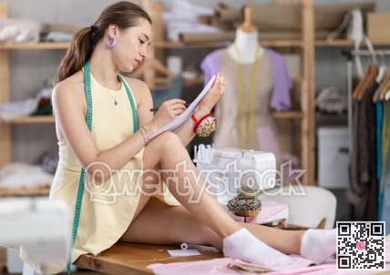 Girl sitting on table drawing sketches on white sheets