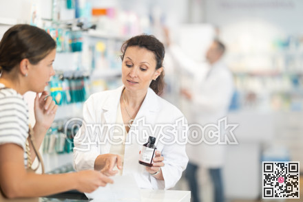 Middle-aged female pharmacist consulting woman client about medicine indicated in her recipe