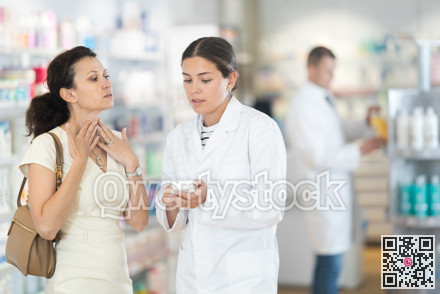 Young female pharmacist offering medicine to woman suffering from pain