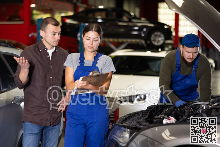 Female worker of auto service speaking to male client concerning her notes on paper