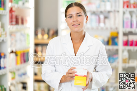 Young female pharmacist offering preparation in box