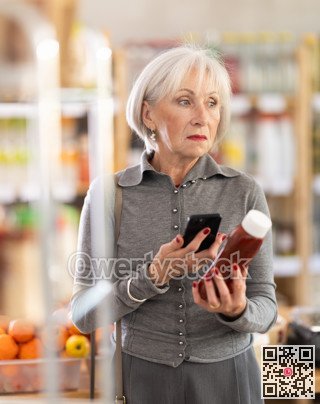 Elderly woman scanning qr code for ketchup
