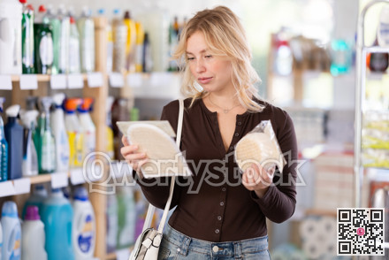 Positive young woman customer buying washcloth in store