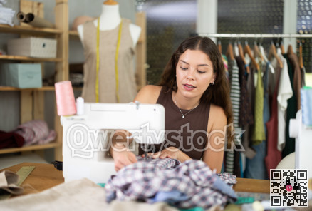 Female fashion designer sewing to order in the workshop
