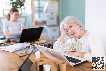 Tired women sleeps next to computer at work.