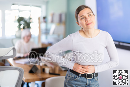 Adult woman with stomach pain during workday in office