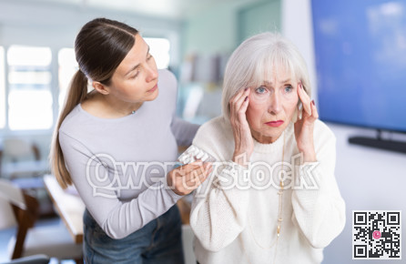 Elderly businesswoman suffers from a headache. Colleague offers her headache pills.