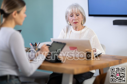 Elderly and adult women working in office