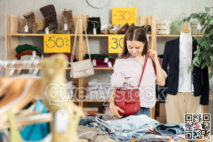 Teenage girl choosing handbag in store