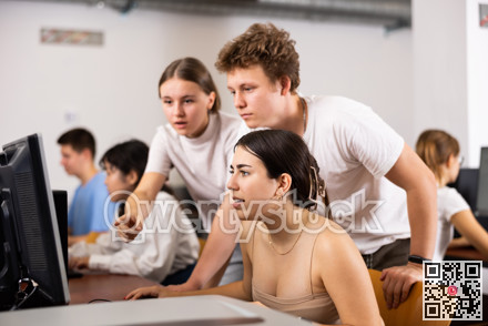 Young boy and girls student emotionally reacting while studying at computer in technology class