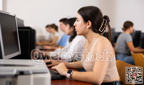 Side view on diligent college girl studying using pc in computer class