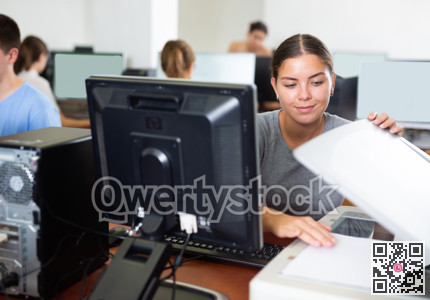 Female teacher uses a scanner in computer lab at school