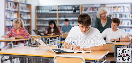 Teenager student sitting at desk in classroom at lesson in high school