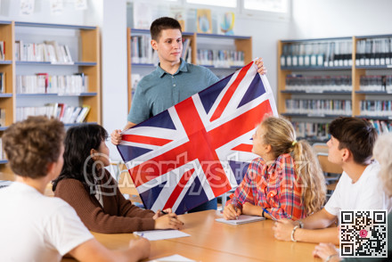 School student boy tells her classmates about the country of Great Britain, holding flag in her hands
