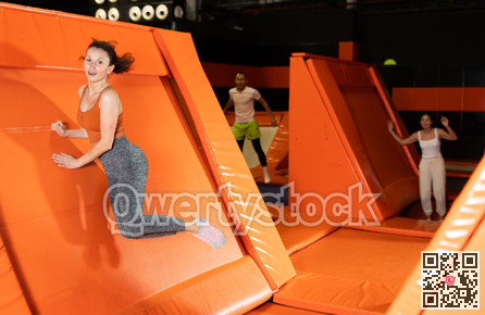 Emotional woman pushing off from angled surface in trampoline park